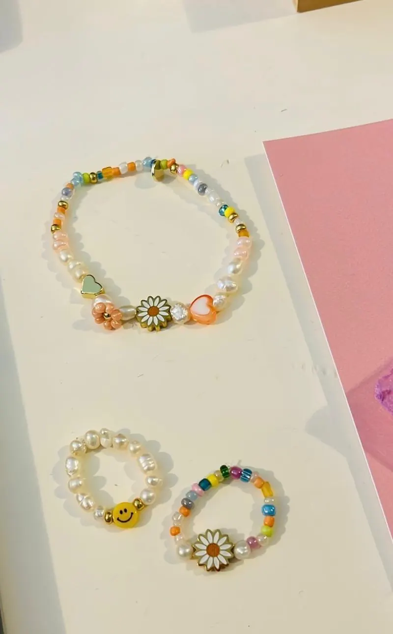 Selbstgemachte bunte Perlenarmbänder mit Gänseblümchen-Anhängern