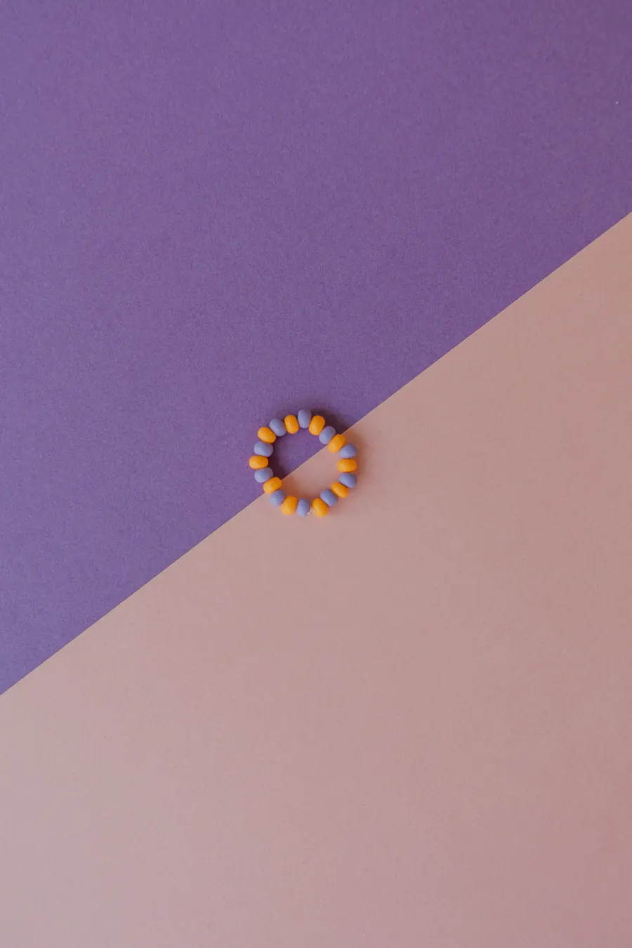 Perlenring auf rosa-lila Hintergrund